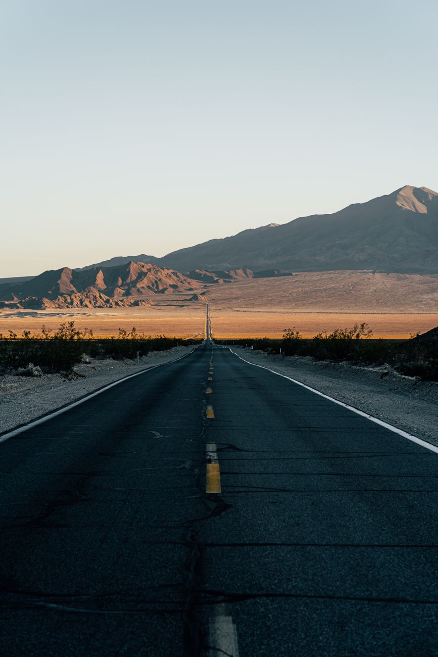 Vast desert highway leading to distant mountain ranges
